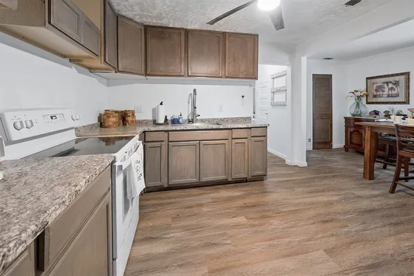 a kitchen with granite countertop a sink stove and cabinets
