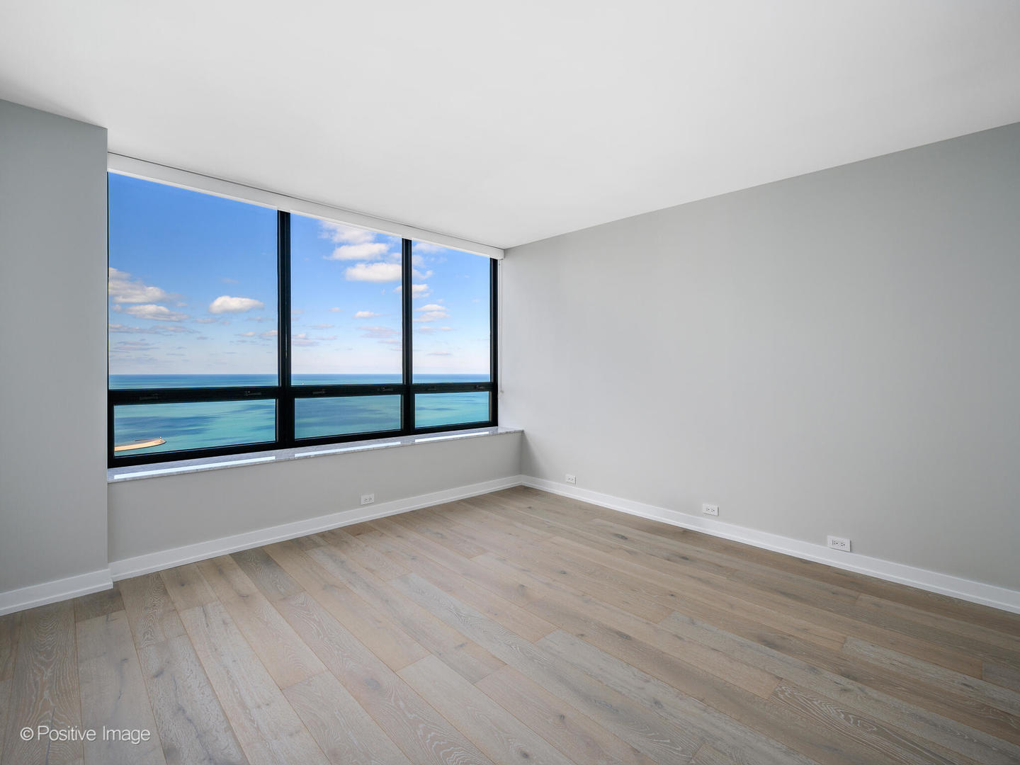 180 East Pearson Street, Unit 6501 Chicago, IL 60611 - Photo 28 of 35 a view of an empty room with wooden floor and a window