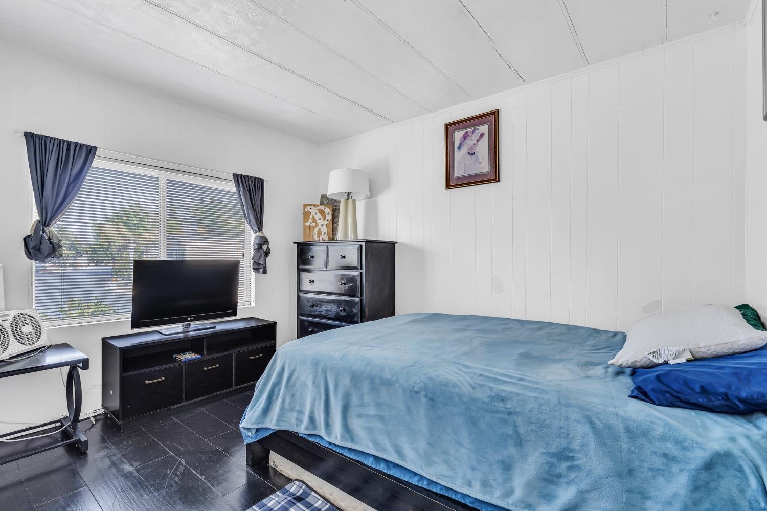 3950 Mack Road, Unit 169 Sacramento, CA 95823 - Photo 7 of 10 a bedroom with a bed and a television