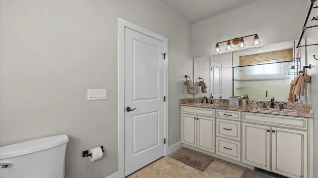 a bathroom with a granite countertop sink mirror and toilet