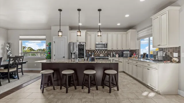 a kitchen with appliances cabinets and chairs
