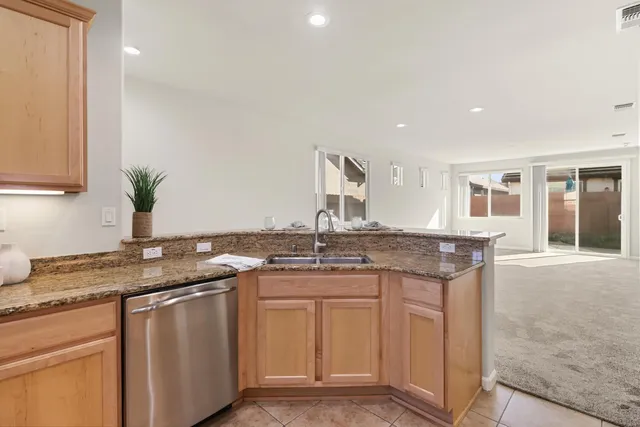 a kitchen with stainless steel appliances granite countertop a sink stove and cabinets