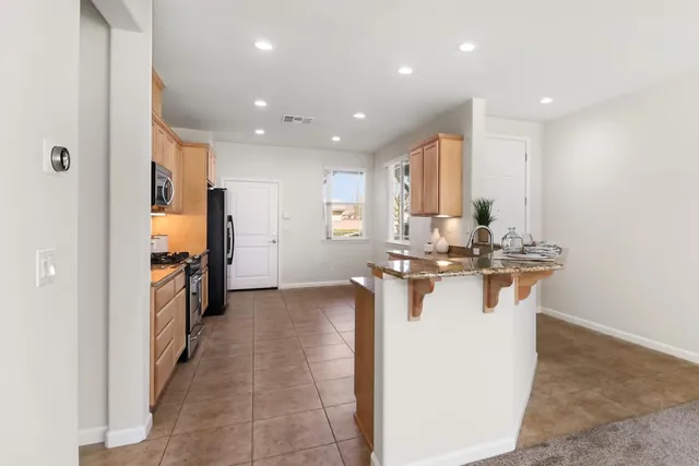 a view of a kitchen with a sink stainless steel appliances cabinets