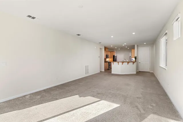 a view of a kitchen with kitchen island a sink a stove and a refrigerator