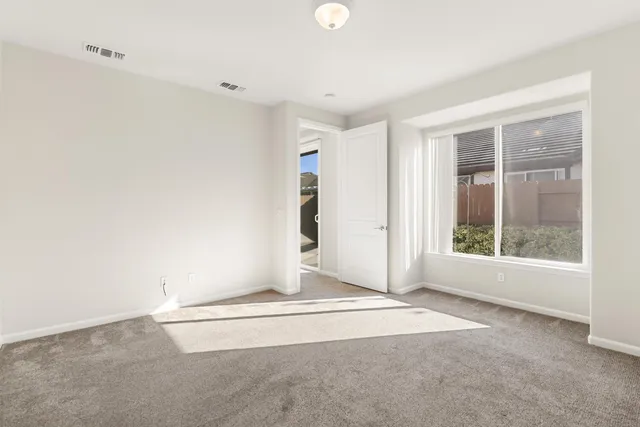 a view of empty room with kitchen