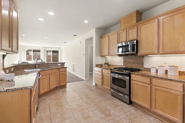 a kitchen with stainless steel appliances granite countertop a stove top oven a sink and dishwasher