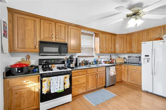 a kitchen with stainless steel appliances granite countertop a stove top oven a refrigerator a sink and dishwasher