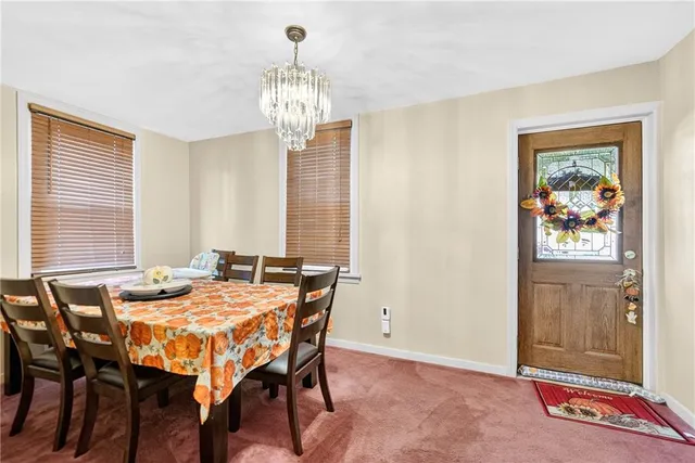 a view of a dining room with furniture and a chandelier