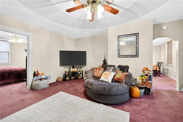 a living room with furniture a chandelier and a window
