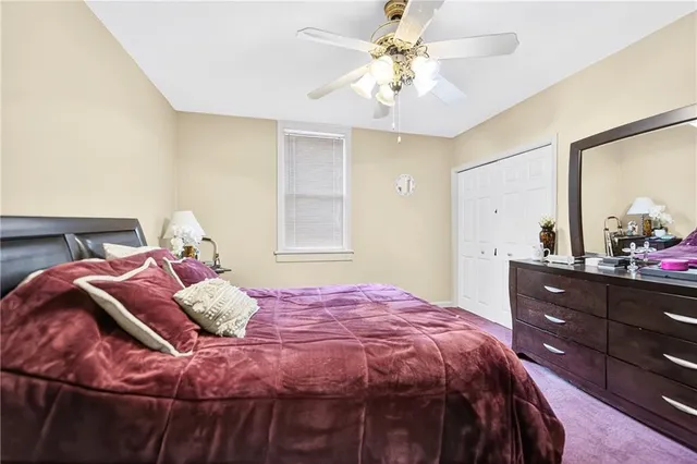a bedroom with a bed and a flat tv screen on dresser