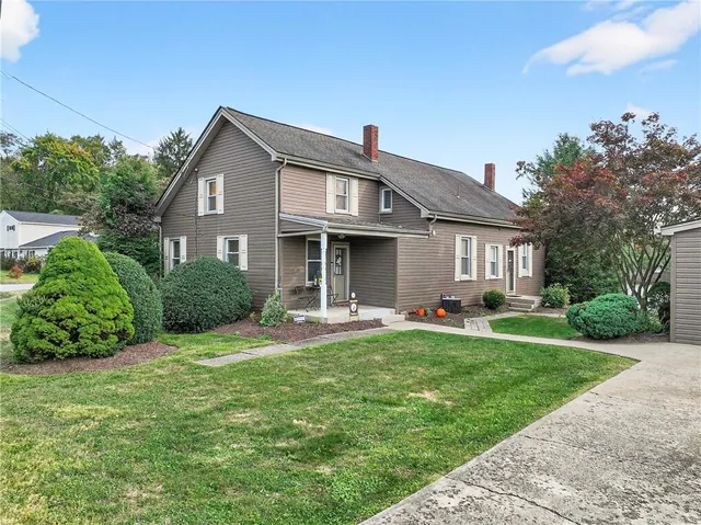 a view of a house with backyard and trees