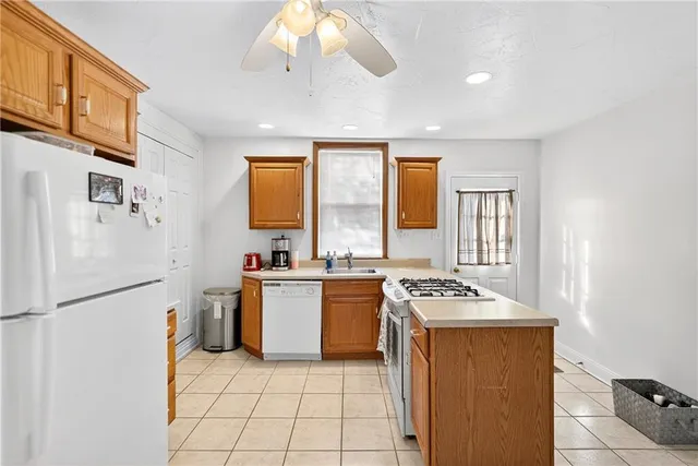 a kitchen with a stove a sink dishwasher and a refrigerator with wooden floor