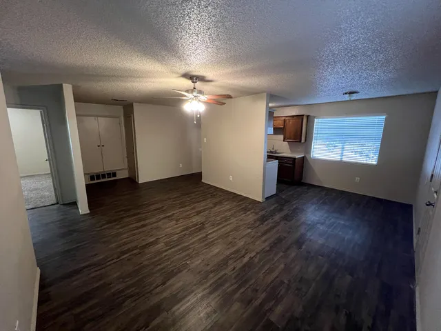 an empty room with wooden floor and window