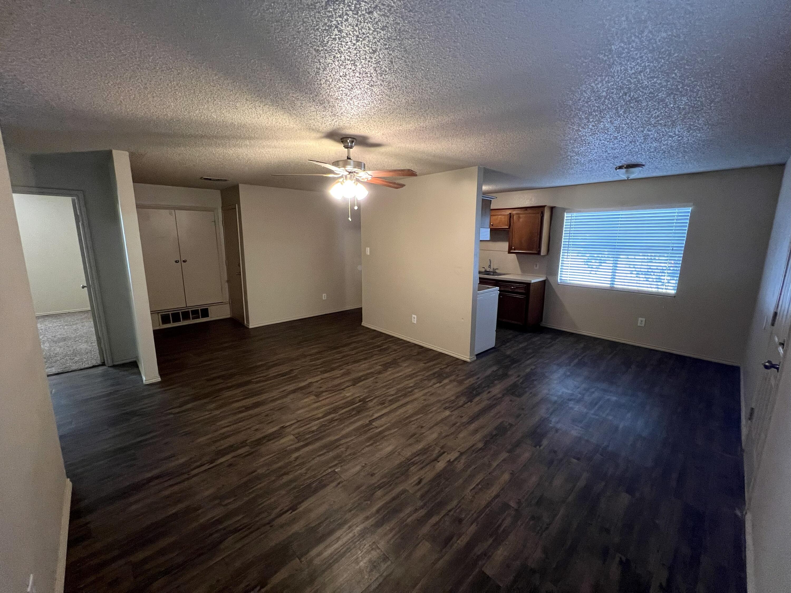 2403 88th Street Lubbock, TX 79423 - Photo 2 of 9 an empty room with wooden floor and window