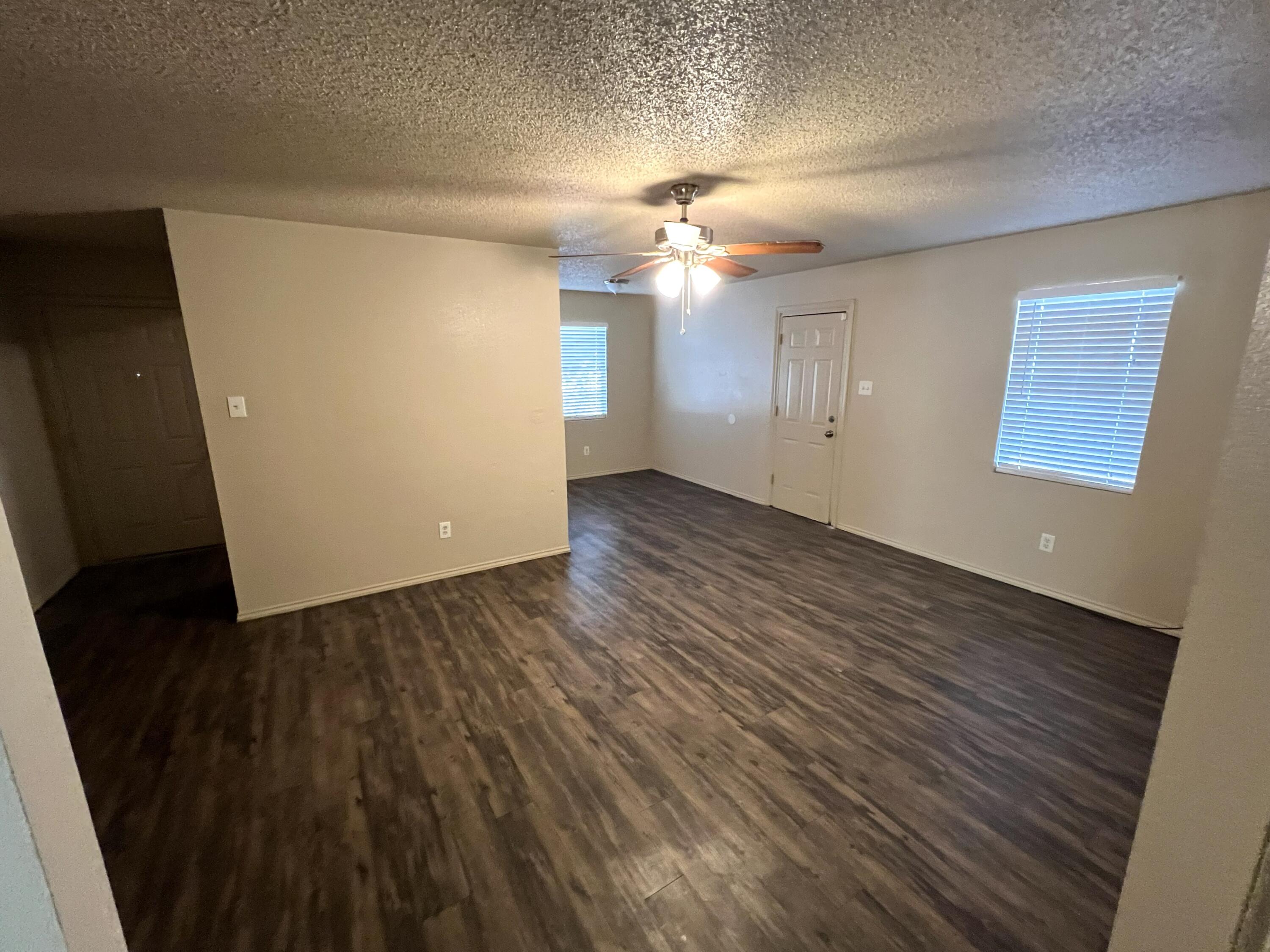 2403 88th Street Lubbock, TX 79423 - Photo 4 of 9 wooden floor in an empty room with a window