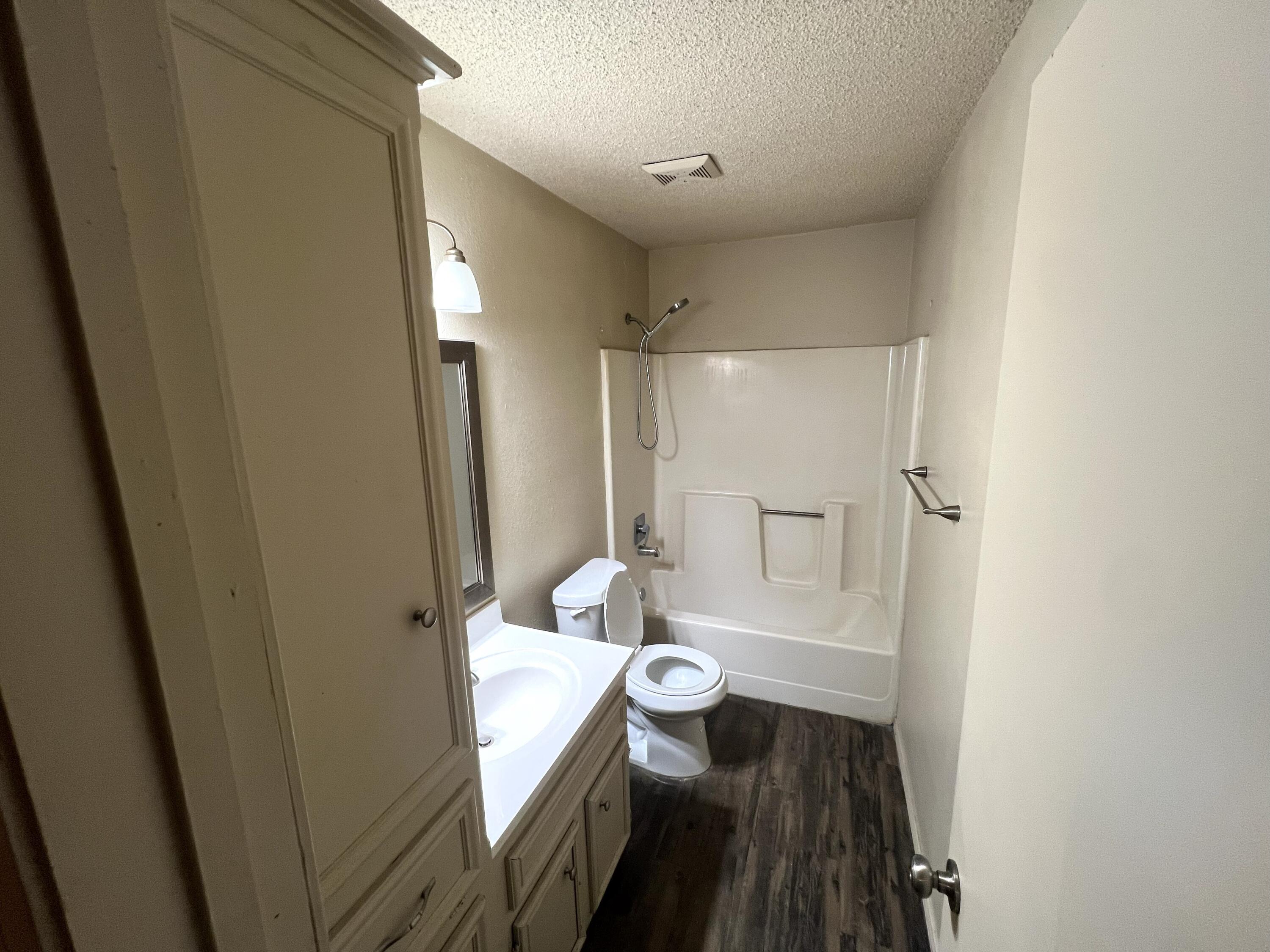 2403 88th Street Lubbock, TX 79423 - Photo 7 of 9 a bathroom with a sink a toilet and shower