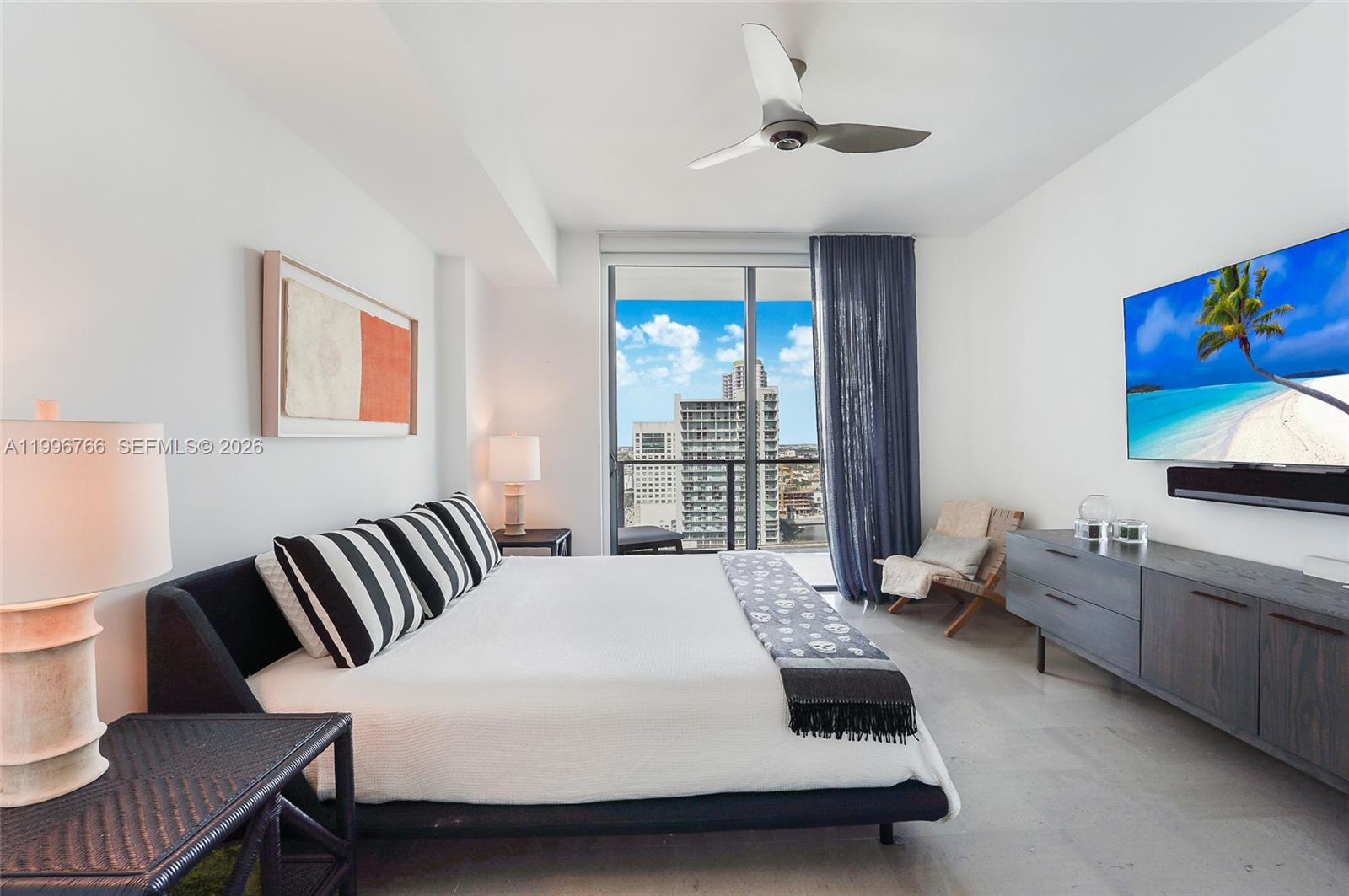68 Southeast 6th Street, Unit 2104 Miami, FL 33131 - Photo 11 of 33 a bedroom with a bed and a flat screen tv
