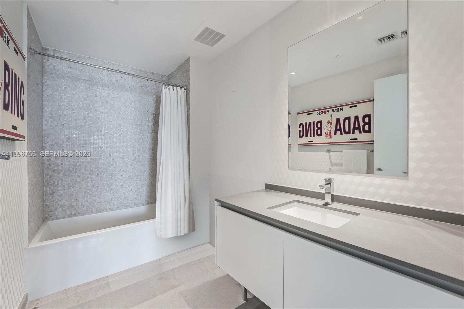 68 Southeast 6th Street, Unit 2104 Miami, FL 33131 - Photo 12 of 33 a bathroom with a sink and a mirror