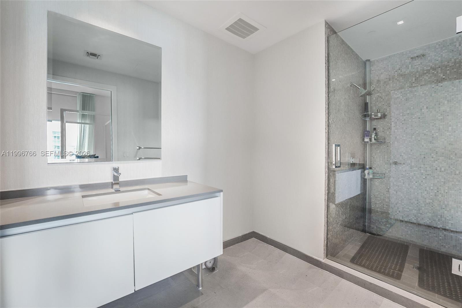 68 Southeast 6th Street, Unit 2104 Miami, FL 33131 - Photo 13 of 33 a bathroom with a sink and a mirror