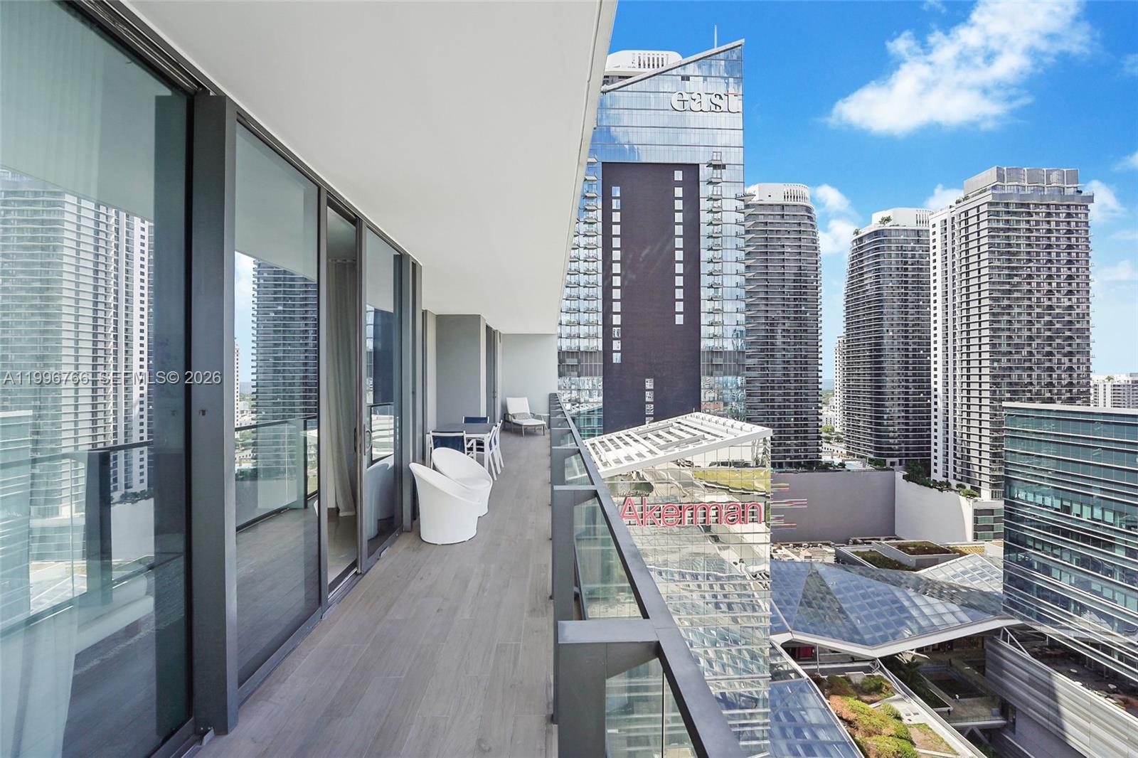 68 Southeast 6th Street, Unit 2104 Miami, FL 33131 - Photo 14 of 33 a view of a balcony with chairs and wooden floor