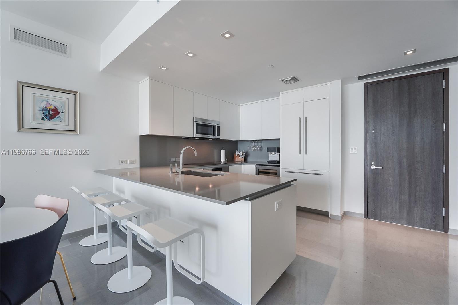 68 Southeast 6th Street, Unit 2104 Miami, FL 33131 - Photo 5 of 33 a kitchen with stainless steel appliances granite countertop a sink a stove a refrigerator and island with wooden floor
