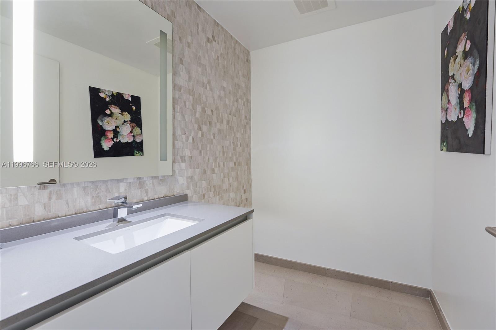 68 Southeast 6th Street, Unit 2104 Miami, FL 33131 - Photo 8 of 33 a bathroom with a sink and a mirror