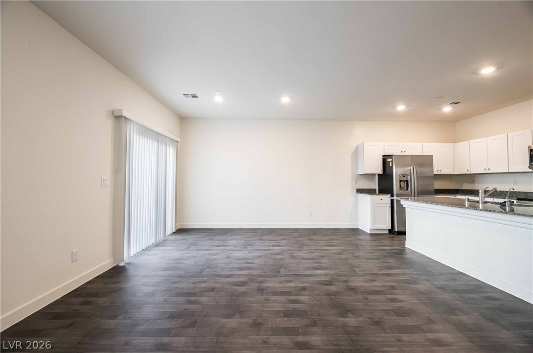 12749 Epperly Street Henderson, NV 89044 - Photo 21 of 22 An open floorplan seamlessly connects the well-appointed kitchen to a generous living area, featuring rich hardwood floors.