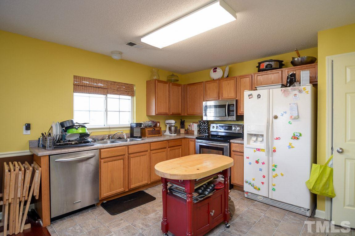 3677 Marshlane Way Raleigh, NC 27610 - Photo 11 of 24 a kitchen with stainless steel appliances granite countertop a stove refrigerator sink and dishwasher