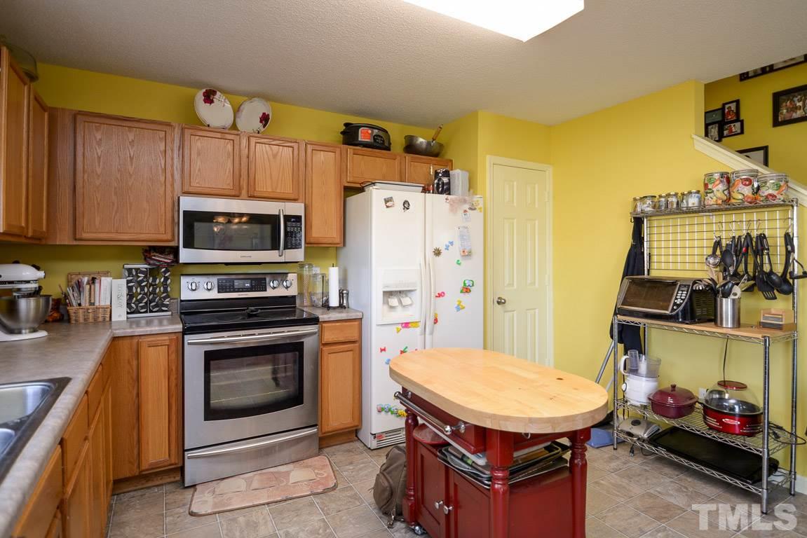 3677 Marshlane Way Raleigh, NC 27610 - Photo 14 of 24 a kitchen with stainless steel appliances a stove a refrigerator a sink a stove and island