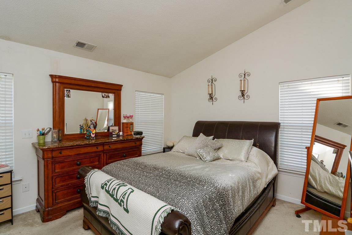 3677 Marshlane Way Raleigh, NC 27610 - Photo 18 of 24 a bedroom with a bed and a mirror on dresser