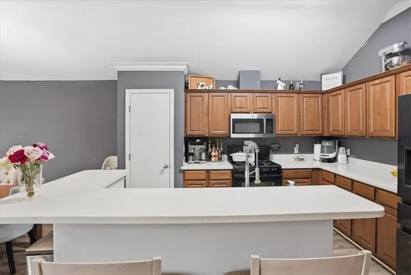 a view of kitchen with kitchen island stainless steel appliances a sink stove and cabinets