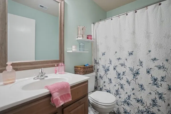 a bathroom with a sink a toilet and a shower curtain