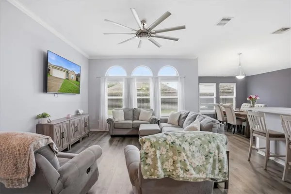 a living room with furniture a large window and a chandelier