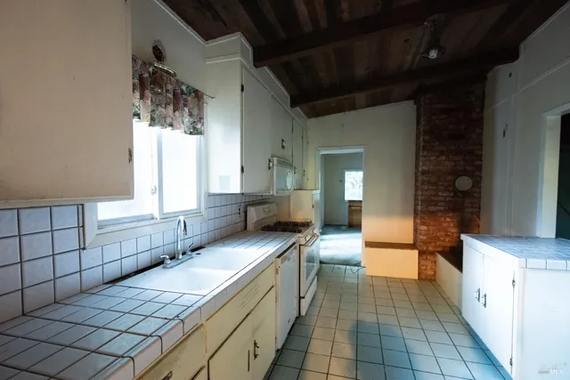 a view of a house with a yard and large trees