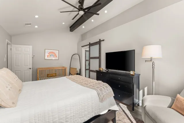 a bedroom with a bed and a flat screen tv