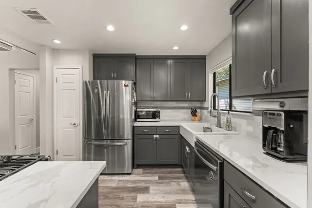 a kitchen with stainless steel appliances a refrigerator sink and microwave