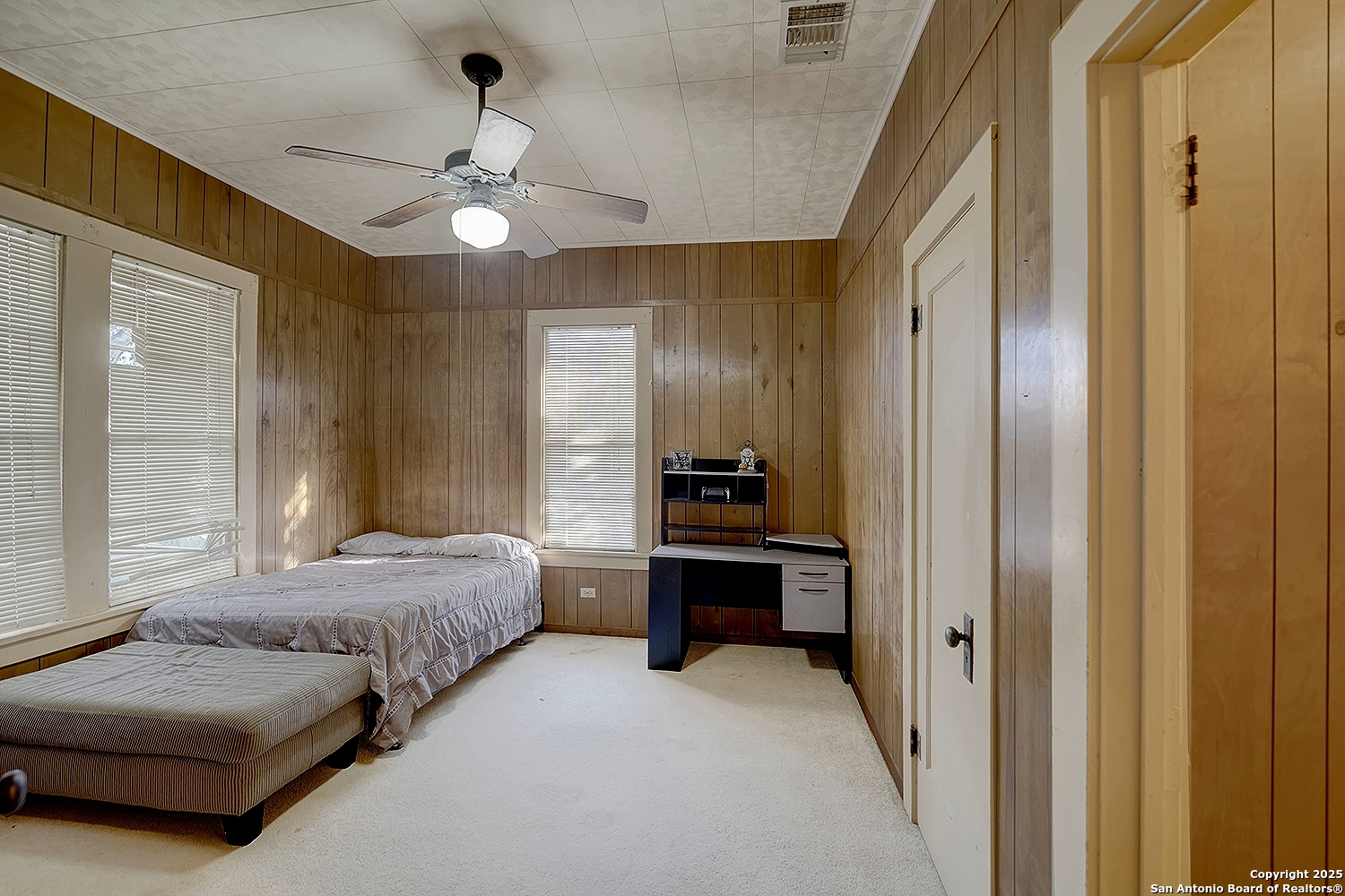 612 East Guadalupe Street Runge, TX 78151 - Photo 25 of 44 a spacious bedroom with a bed and a chandelier