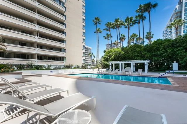 a view of a swimming pool with a chair and tables in the patio