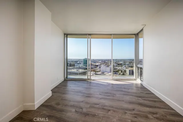 an empty room with wooden floor and balcony