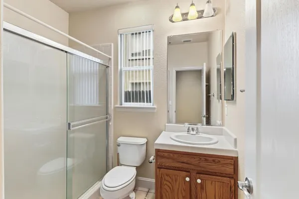 a bathroom with a granite countertop sink toilet and shower