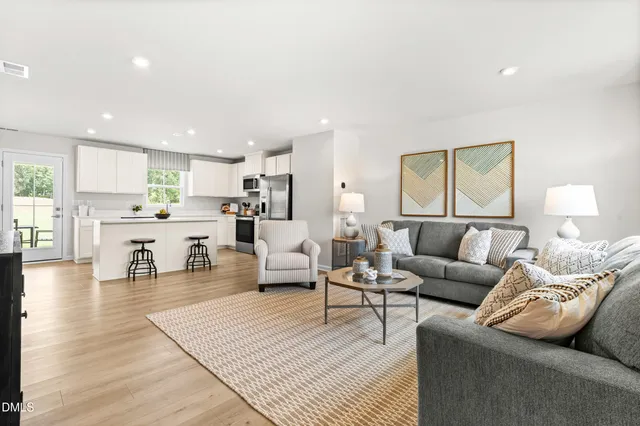 a living room with furniture and view of kitchen