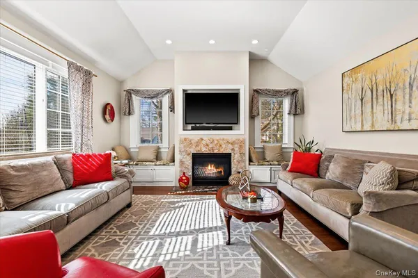 a living room with furniture a flat screen tv and a fireplace