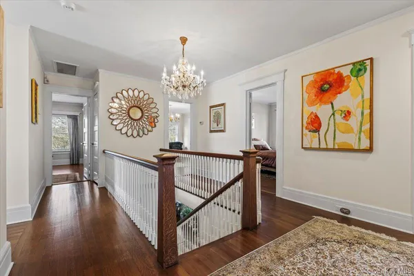 a view of a hallway with wooden floor and staircase