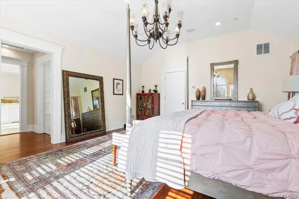 a bedroom with a large bed and a chandelier