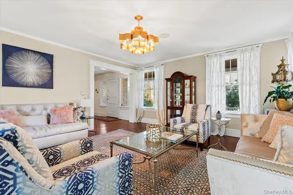 a living room with furniture a chandelier and a rug