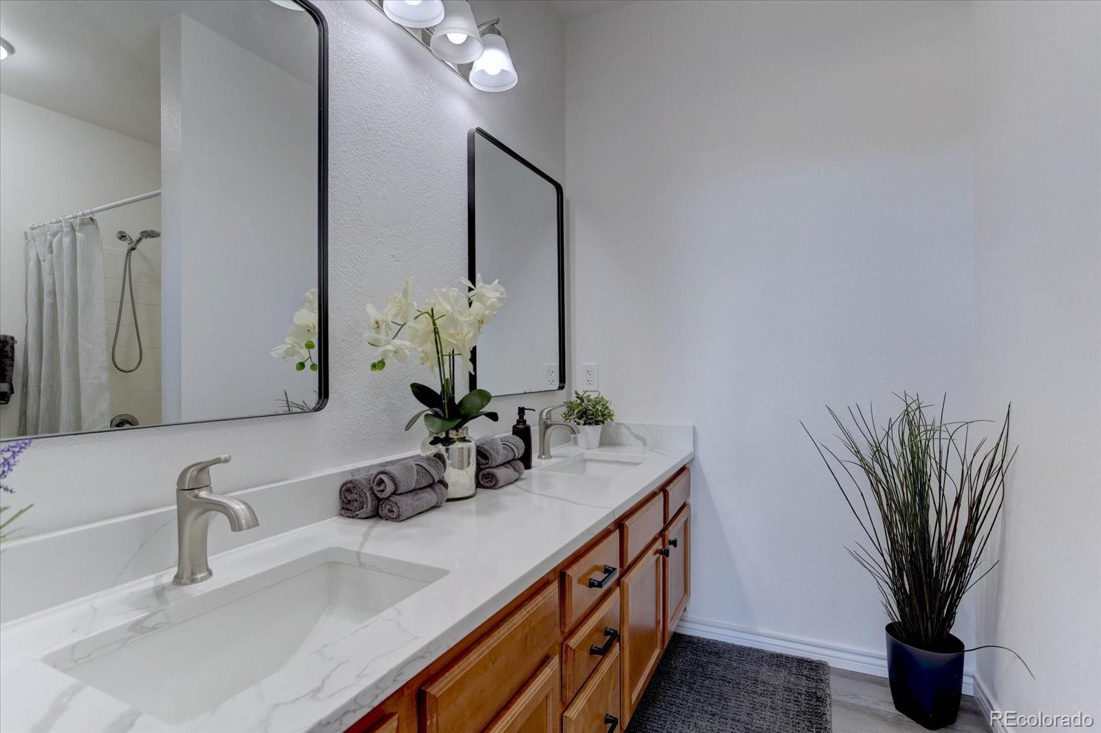 18657 Stroh Road, Unit 4107 Parker, CO 80134 - Photo 11 of 25 a bathroom with a double vanity sink and a mirror