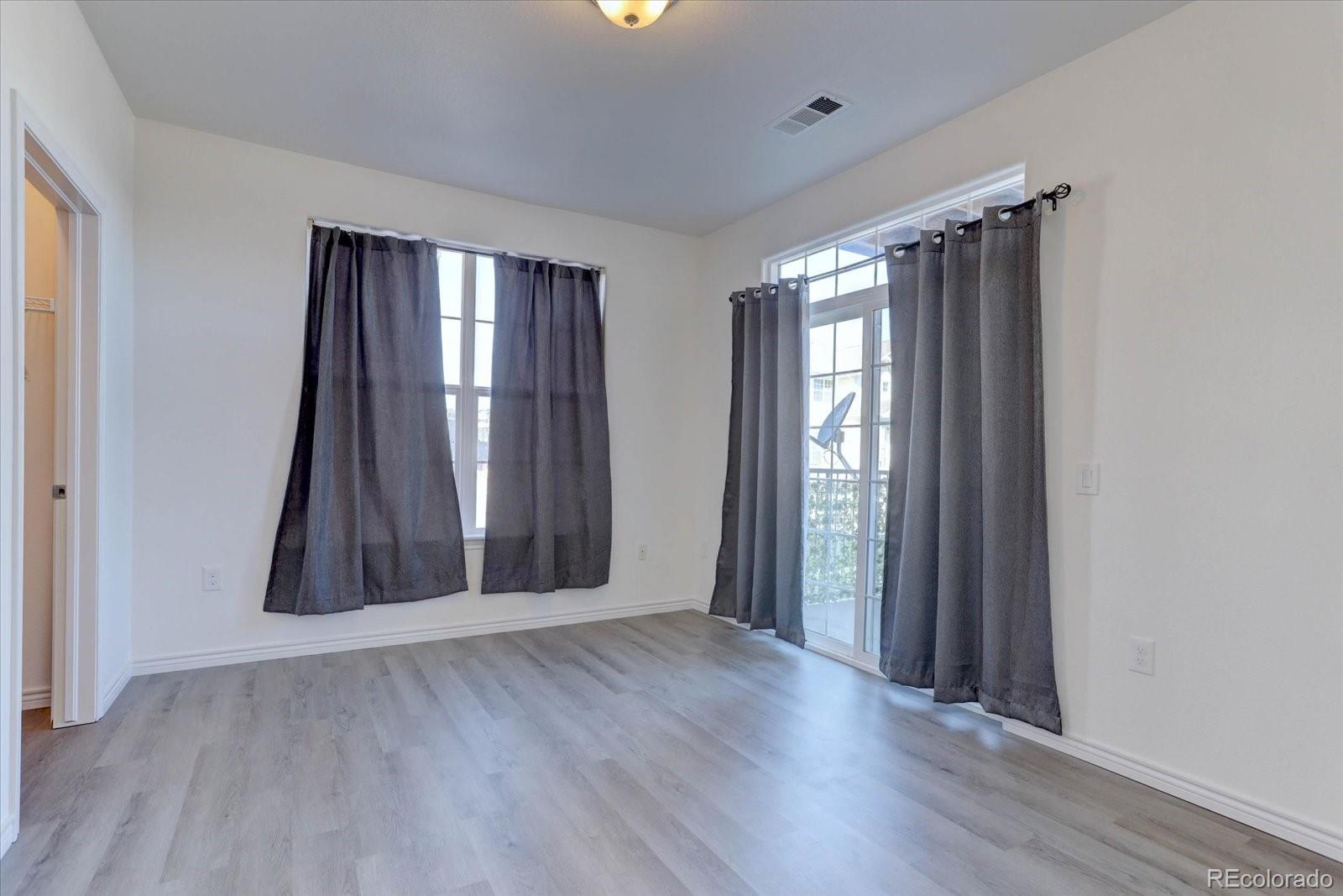 18657 Stroh Road, Unit 4107 Parker, CO 80134 - Photo 17 of 25 an empty room with wooden floor and windows