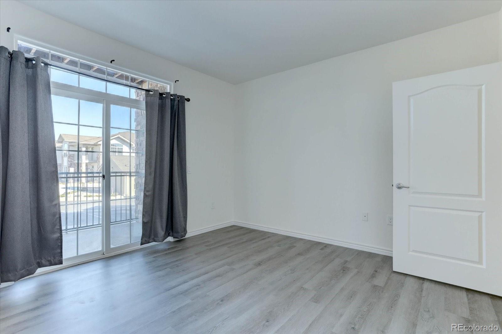 18657 Stroh Road, Unit 4107 Parker, CO 80134 - Photo 10 of 25 a view of an empty room with wooden floor and a window