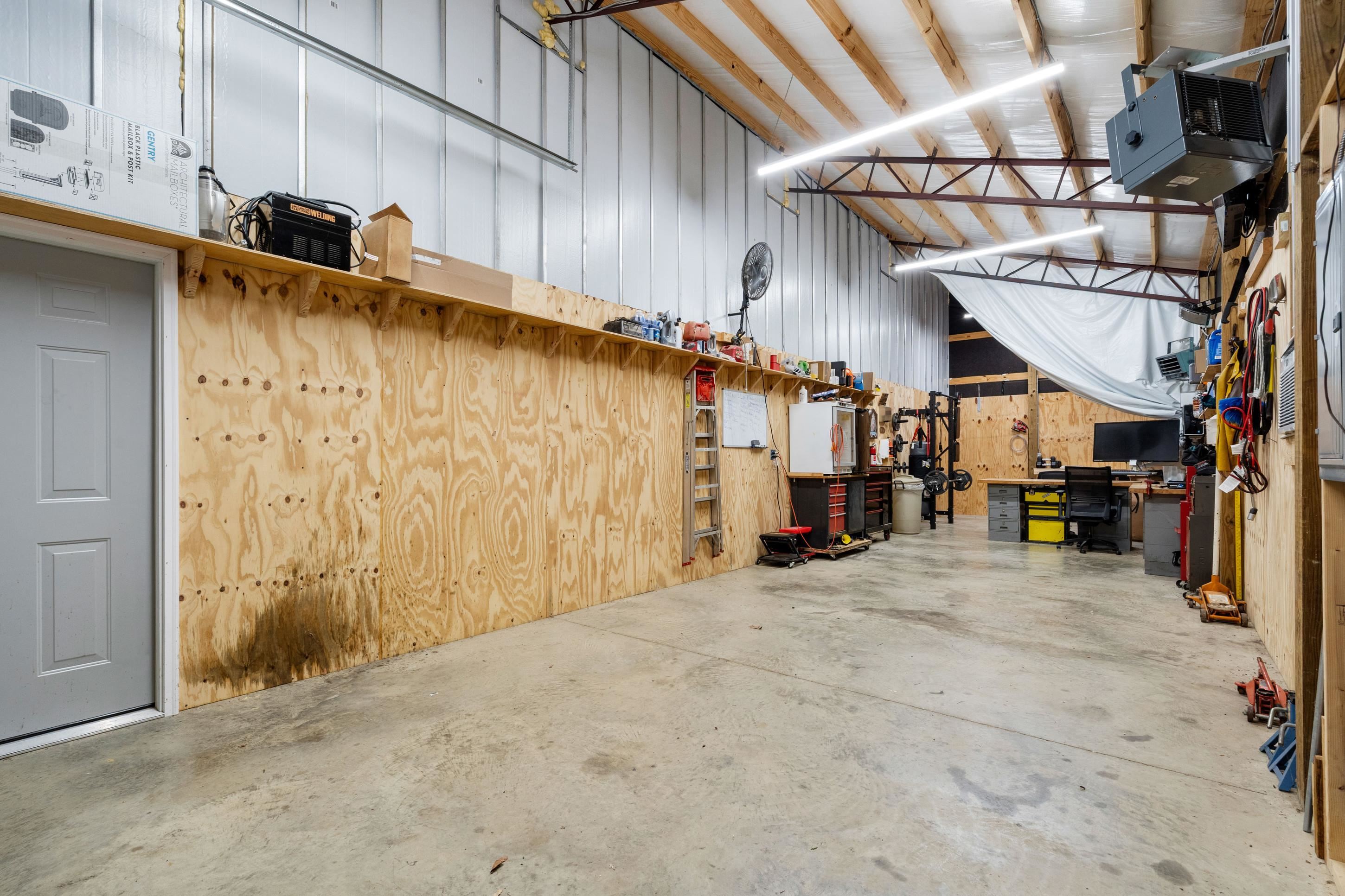 7757 Brunswick Road Millington, TN 38053 - Photo 34 of 40 Spacious interior featuring metal-clad walls, exposed wooden roof trusses, and concrete flooring