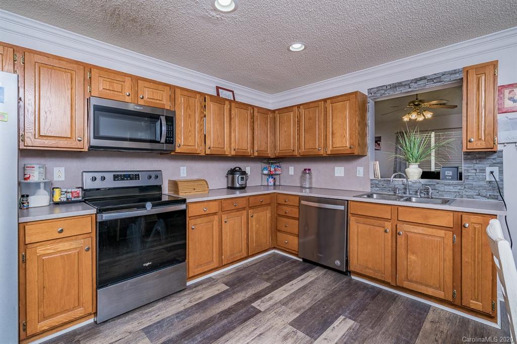 772 Raindrops Road Gastonia, NC 28054 - Photo 8 of 28 a kitchen with stainless steel appliances granite countertop wooden cabinets sink and a granite counter top